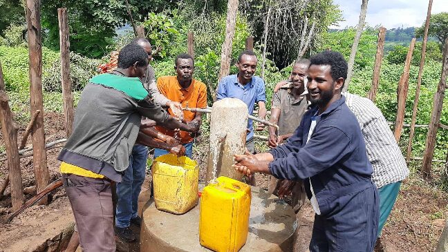 men at water well